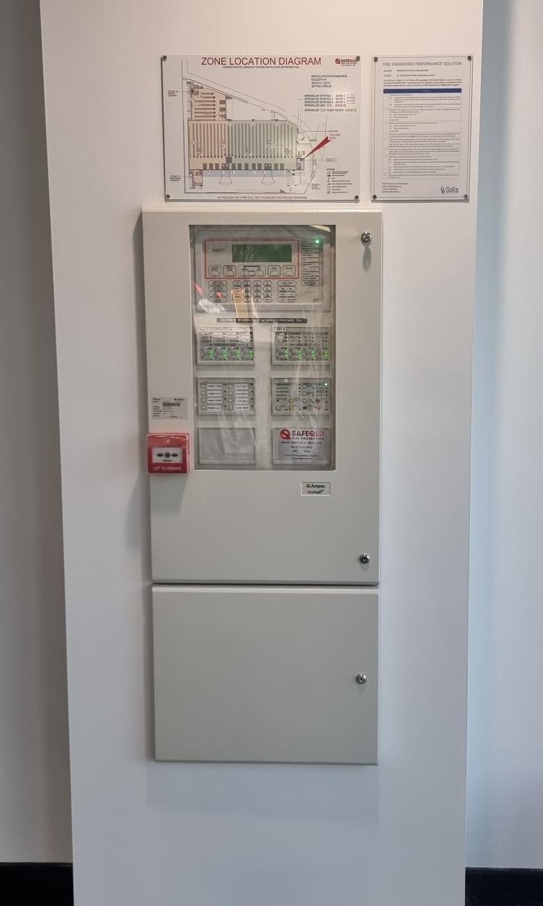 Fire alarm control panel in wall cabinet with zone diagram and service records