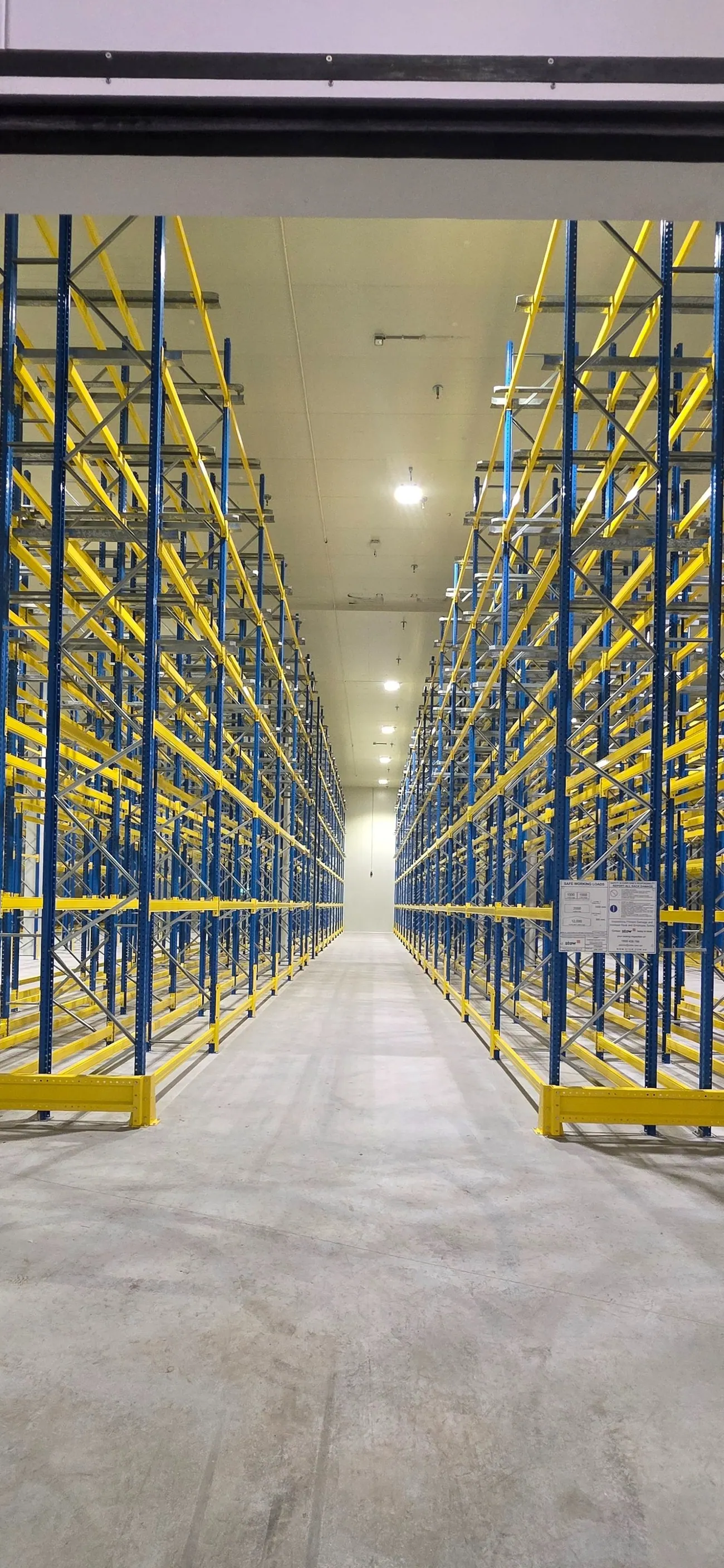 High-bay racking in a warehouse where in-rack sprinkler protection is designed and maintained by Safe QLD Fire Protection