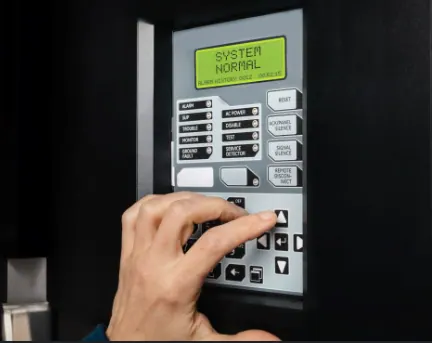 Addressable fire panel showing a device status check during a routine, with the sprinkler solenoid test switches below, by Safe QLD Fire Protection